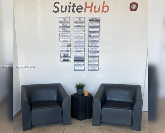 Two black armchairs sit on either side of a small table in a building lobby — 3500 NW 114th Ave # 107, Doral FL 33178, DORAL, FL