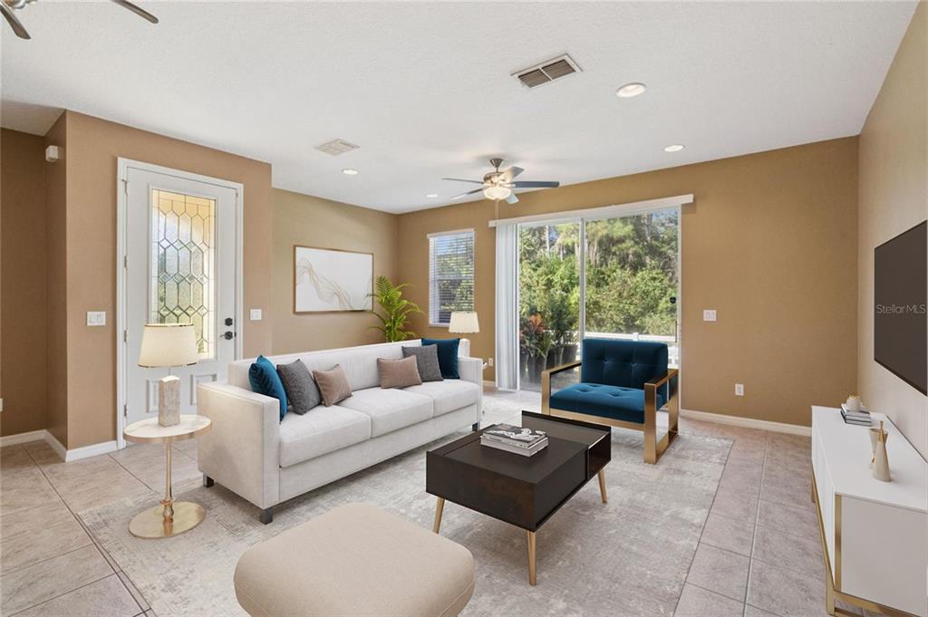 A living room features a white sofa, a blue armchair, a coffee table, and tile flooring — 10376 FALLSGROVE STREET, ORLANDO, FL