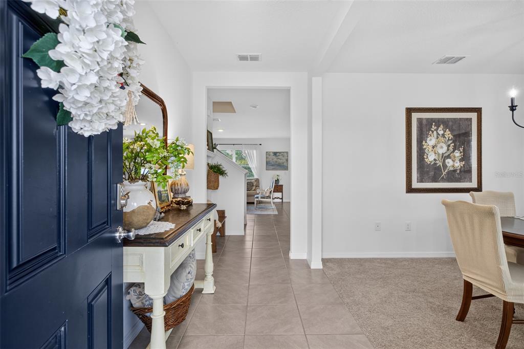 An entryway features tile flooring, a white front door, and a wooden console table — 3995 MEKONG COURT, ST CLOUD, FL
