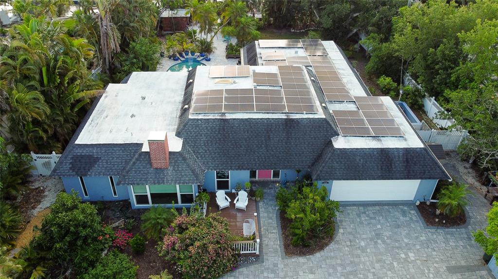 An aerial view of a blue house with a shingled roof and solar panels — 4925 PRIMROSE PATH, SARASOTA, FL