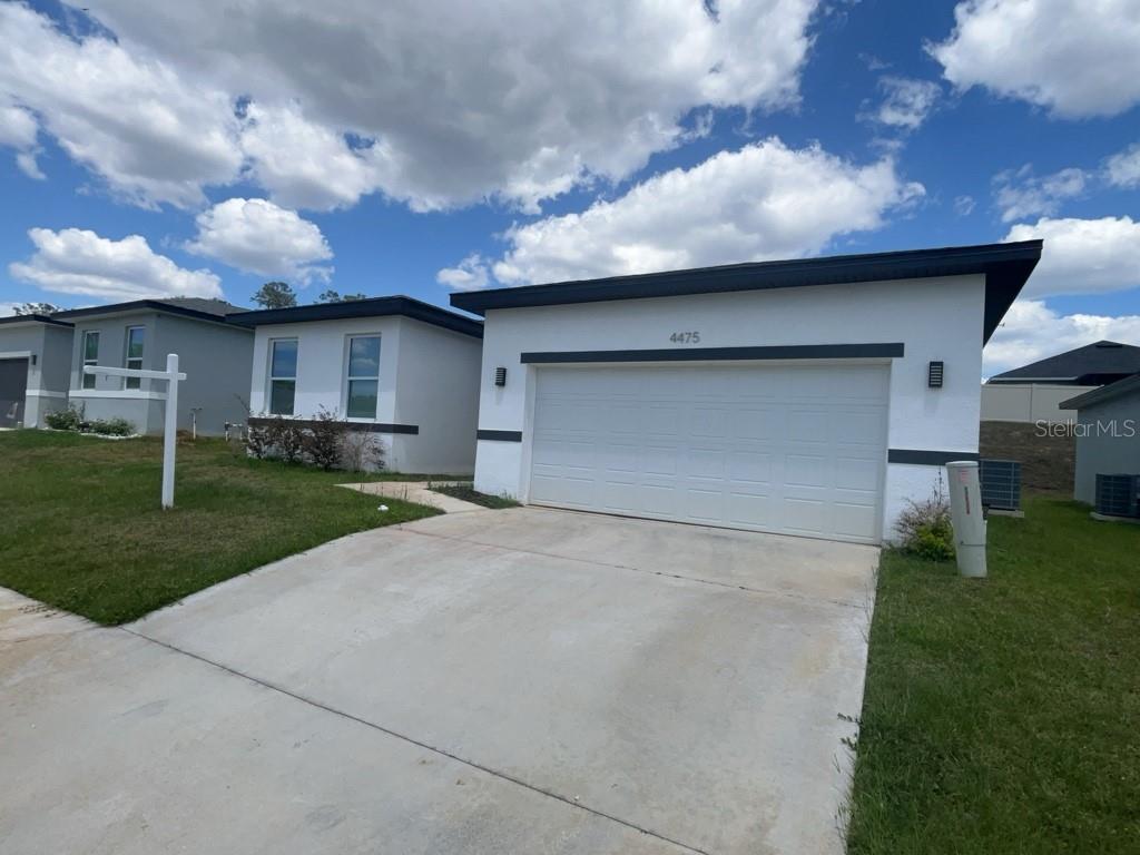 A white single-story house features a two-car garage and a concrete driveway — 4475 NW 1ST TERRACE, OCALA, FL