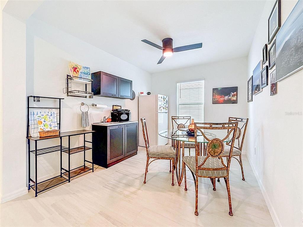 A dining room features a glass table, four chairs, and a small kitchenette area — 12227 RADIANT GEM TRAIL, PARRISH, FL