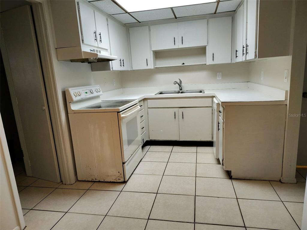 A kitchen with white cabinets, white appliances, and light-colored tile flooring — 3715 COLBY STREET, SARASOTA, FL