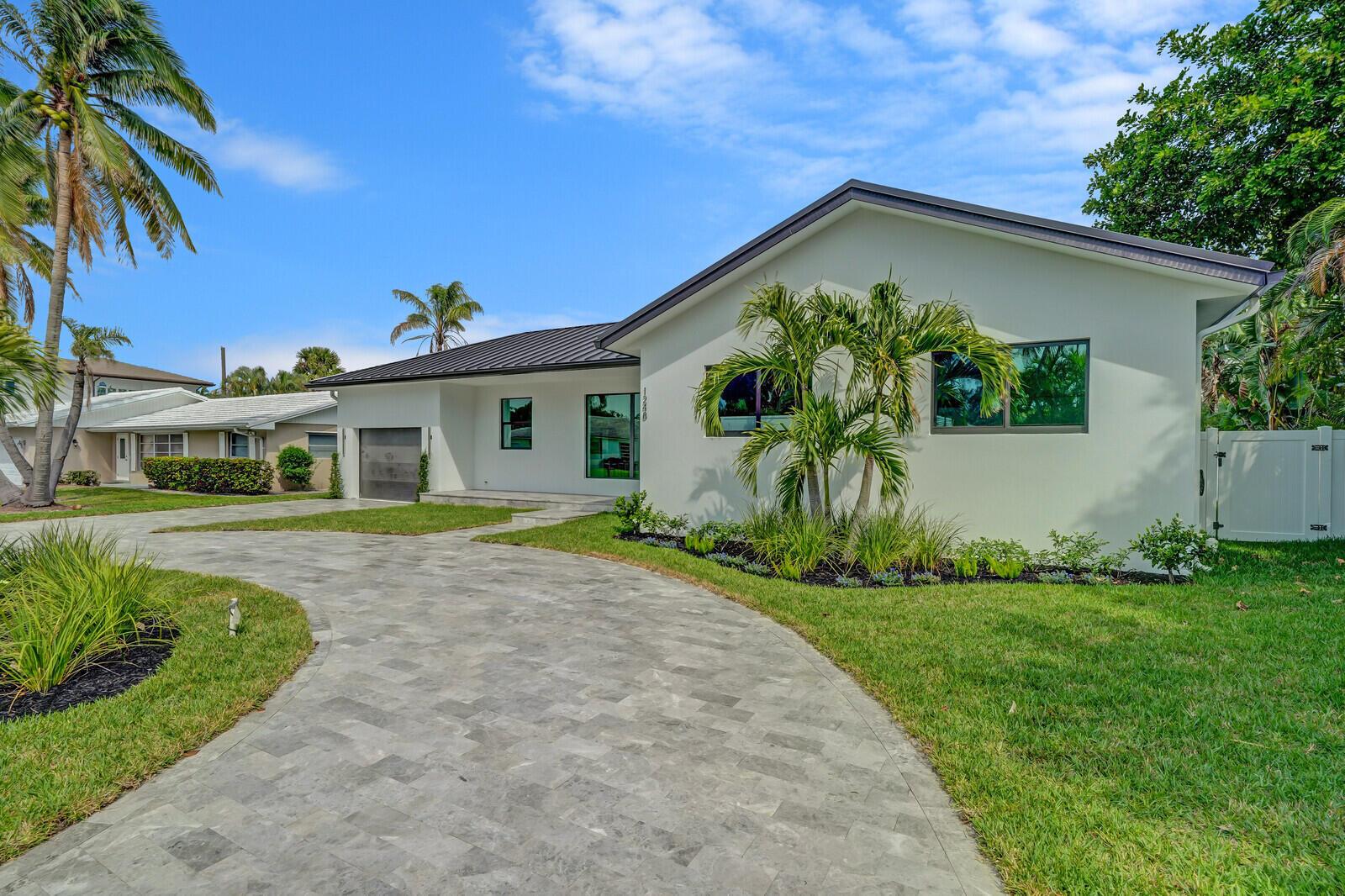 A modern white house with a metal roof and a stone paver driveway — 1248 N Harbor Drive, Singer Island FL 33404, SINGER ISLAND, FL