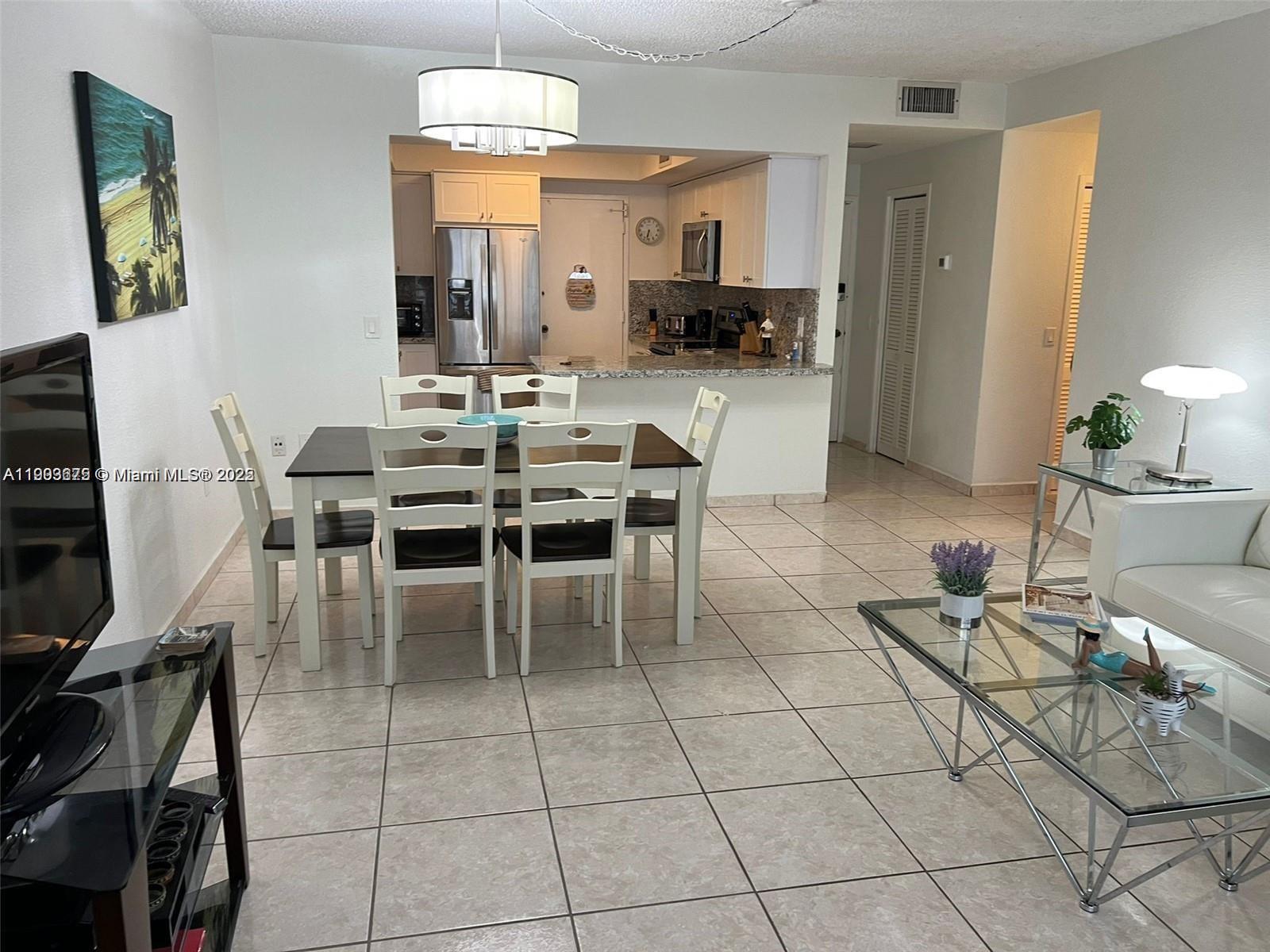 A dining area with a table and chairs sits adjacent to an open-concept kitchen — 3505 S Ocean Dr # 208, Hollywood FL 33019, HOLLYWOOD, FL