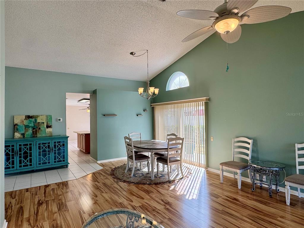A dining area with wood-look flooring, a ceiling fan, and a blue sideboard — 4720 PERIDIA BOULEVARD E, BRADENTON, FL