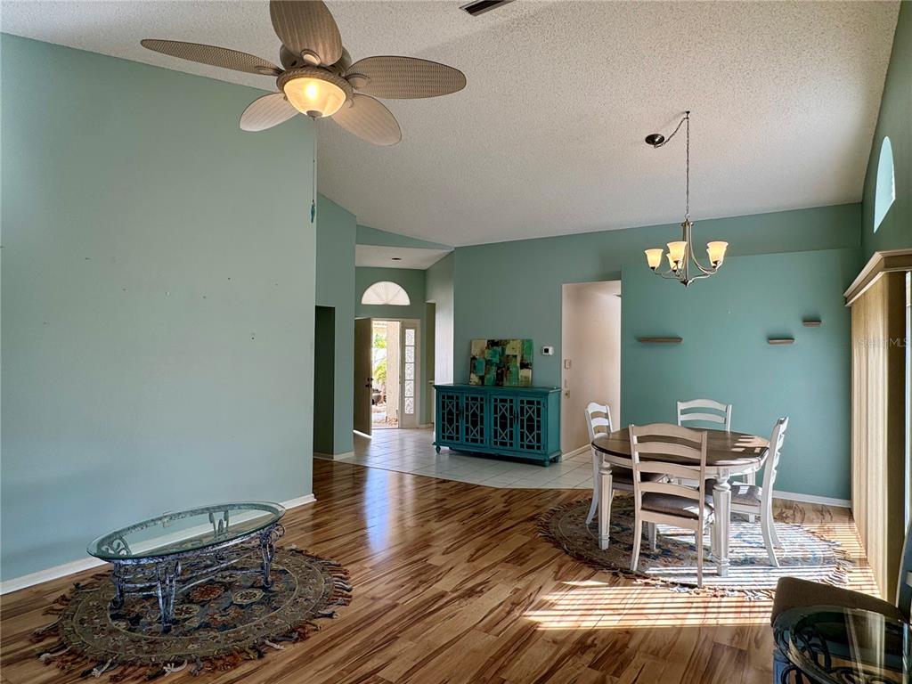 A living and dining area with teal walls, wood-look flooring, and a ceiling fan — 4720 PERIDIA BOULEVARD E, BRADENTON, FL