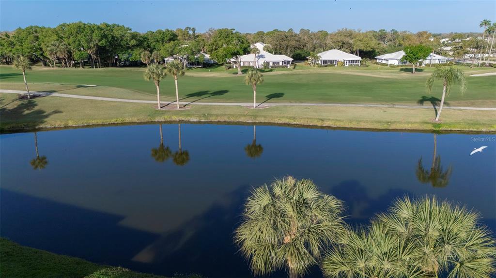 An elevated view of a pond, a golf course, and several houses in the distance — 425 CERROMAR TERRACE UNIT 459, VENICE, FL