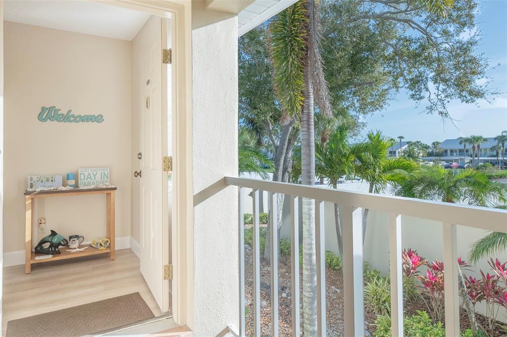 An open door leads from a balcony into an entryway with a console table — 425 CERROMAR TERRACE UNIT 459, VENICE, FL