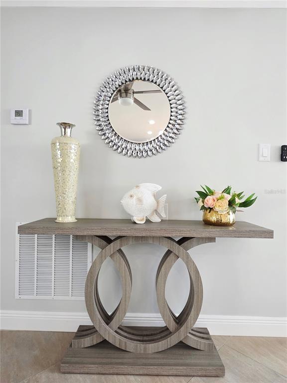 A console table with a circular base sits against a wall beneath a decorative mirror — 3435 OVERLOOK DRIVE NE, ST PETERSBURG, FL