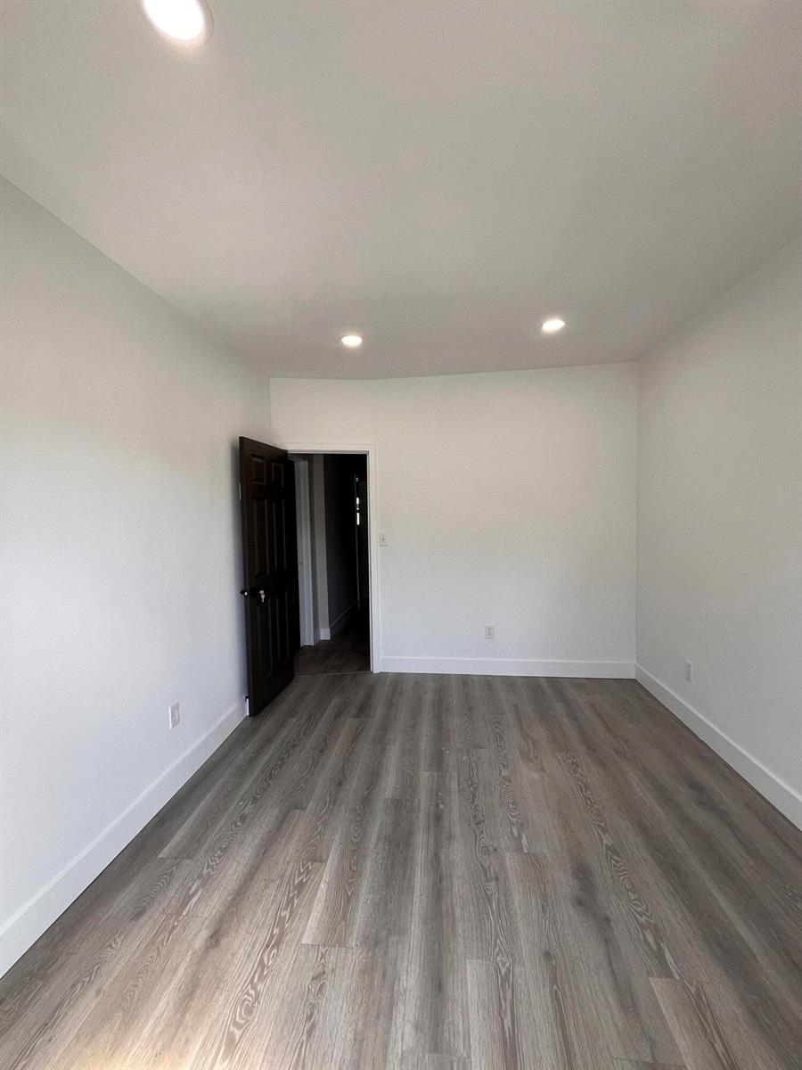 An empty room with white walls, recessed lighting, and gray wood-look flooring — 900 Federal Highway, Riviera Beach FL 33403, RIVIERA BEACH, FL
