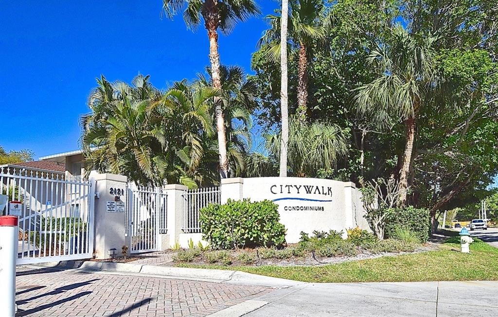 The entrance to Citywalk Condominiums features a white sign, gated entry, and palm trees — 2121 WOOD STREET UNIT 201, SARASOTA, FL