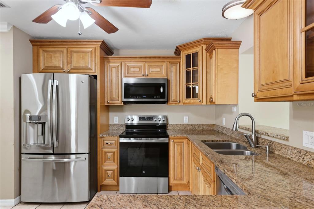 A kitchen featuring light wood cabinets, granite countertops, and stainless steel appliances — 3413 51ST AVENUE CIRCLE W UNIT 205, BRADENTON, FL