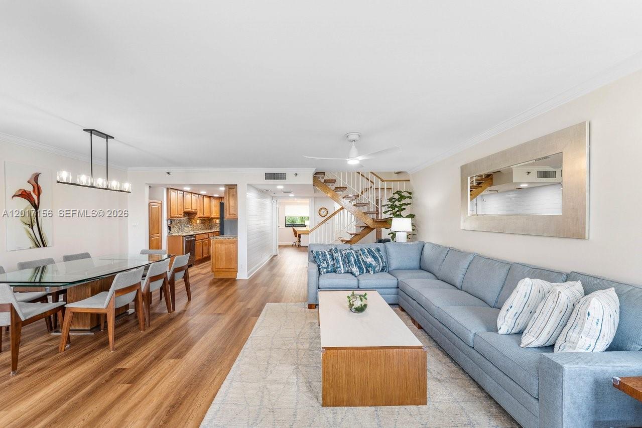 A living room and dining area feature wood flooring, a blue sectional, and a staircase — 364 Golfview Rd # 505, North Palm Beach FL 33408, NORTH PALM BEACH, FL