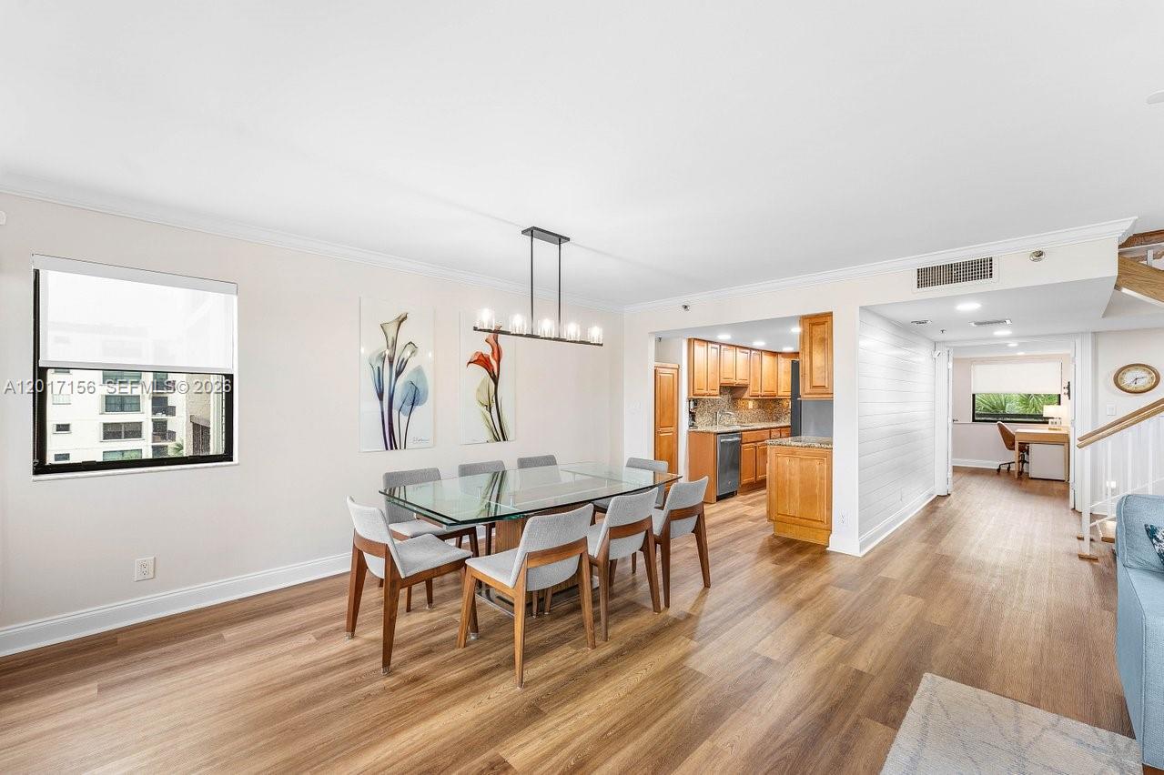 A dining area with a glass table and chairs sits adjacent to a wooden kitchen — 364 Golfview Rd # 505, North Palm Beach FL 33408, NORTH PALM BEACH, FL