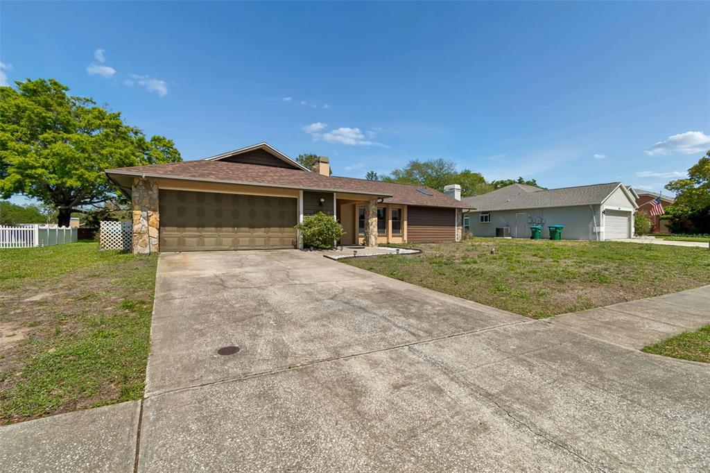 A single-story house with a two-car garage, stone accents, and a concrete driveway — 1039 NORTHRIDGE DRIVE, PALM HARBOR, FL