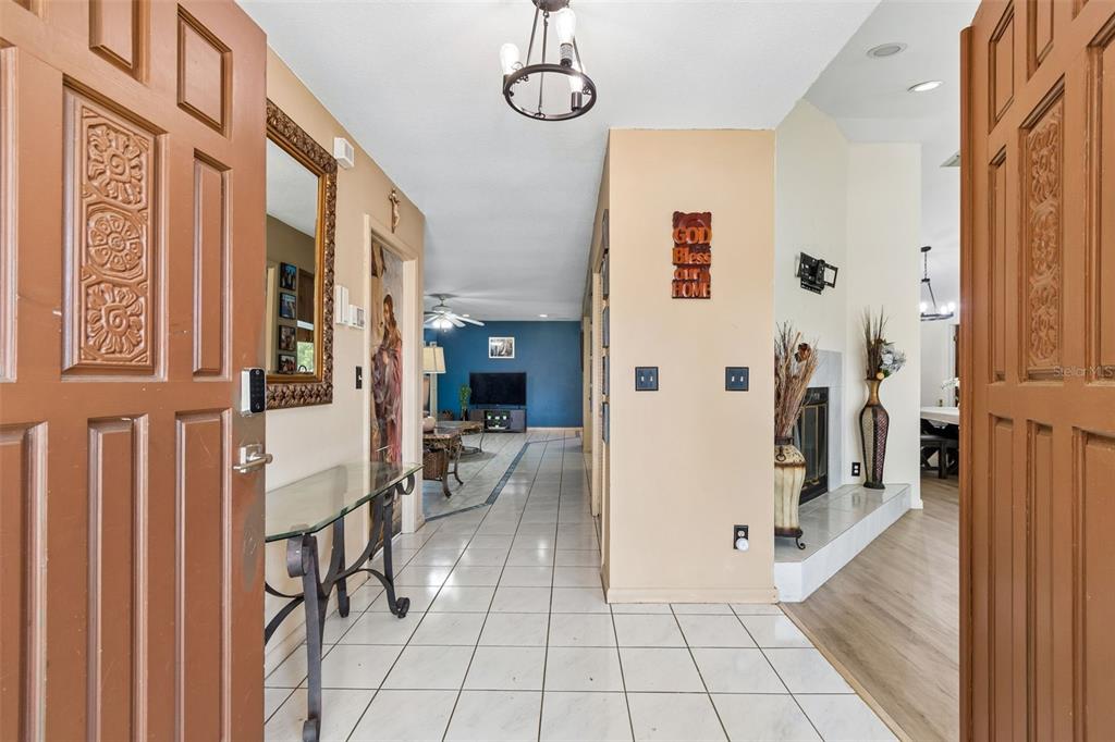 An entryway with tiled floors leads to a living area with a blue accent wall — 1039 NORTHRIDGE DRIVE, PALM HARBOR, FL
