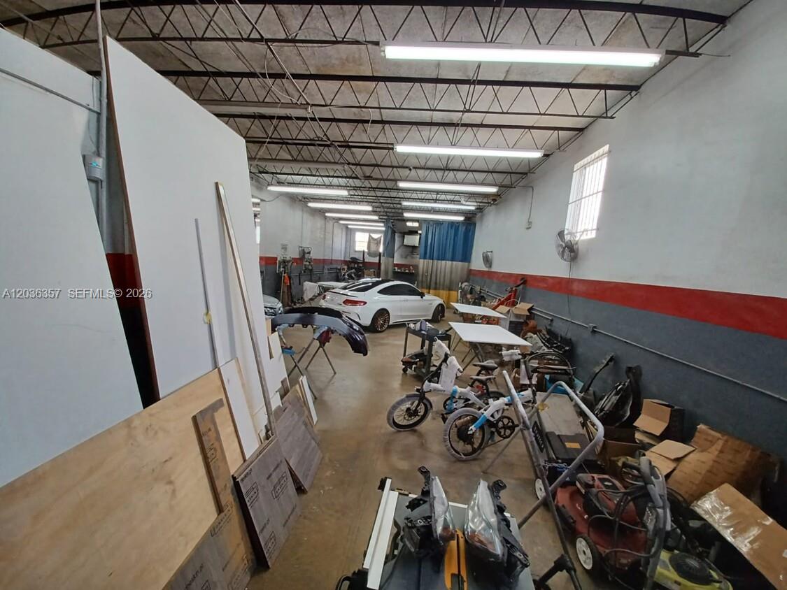 An industrial workshop space features a white car, bicycles, and various tools and materials — 707 N Dixie Hwy, Hallandale Beach FL 33009, HALLANDALE BEACH, FL