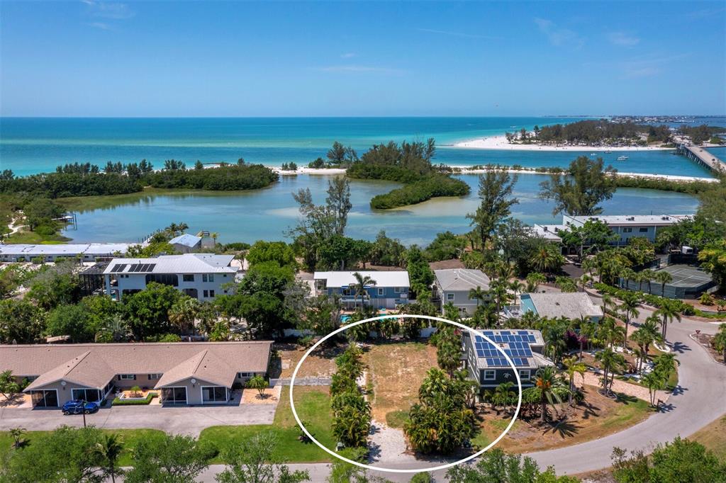 An aerial view shows a vacant, rectangular lot surrounded by trees and residential buildings — 450 FIREHOUSE COURT, LONGBOAT KEY, FL