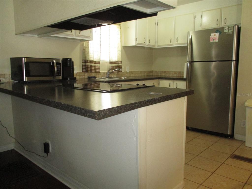 A kitchen features white cabinets, a dark countertop, and stainless steel appliances — 92 ROSALIE OAKS BOULEVARD, LAKE WALES, FL