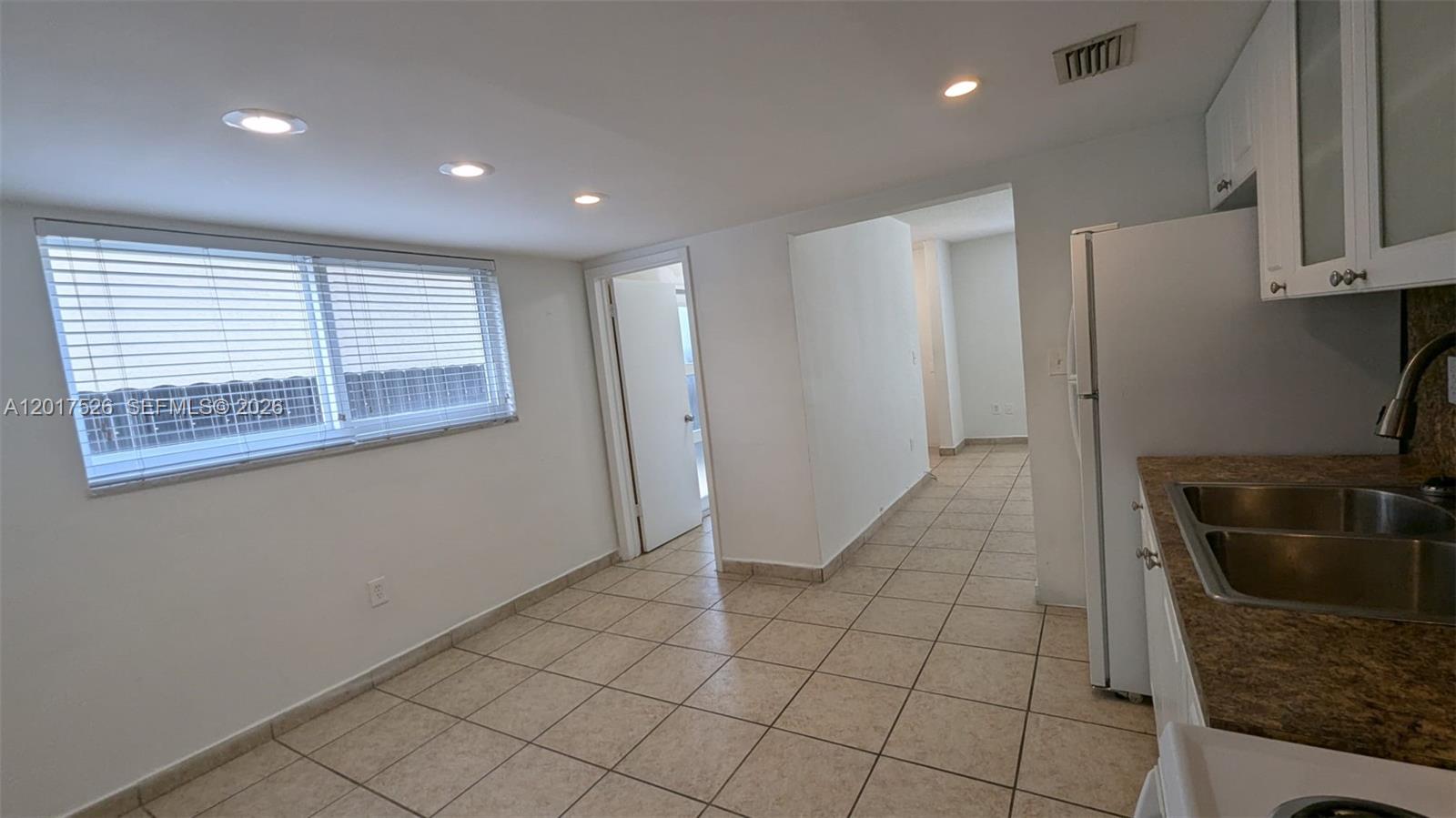 A kitchen with tile flooring, a double sink, and a window with white blinds — 3525 SW 25th Ter # 1, Miami FL 33133, MIAMI, FL
