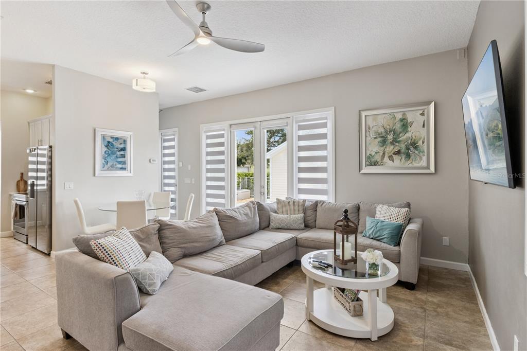 A living room features a large sectional sofa, a coffee table, and glass patio doors — 7407 OCONEE ST, REUNION, FL