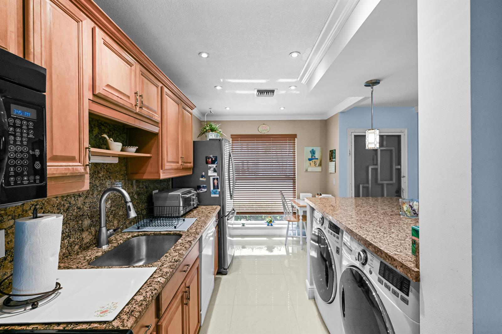 A kitchen with wood cabinets, granite countertops, stainless steel appliances, and a laundry area — 2730 SW 15th Street # a, Delray Beach FL 33445, DELRAY BEACH, FL