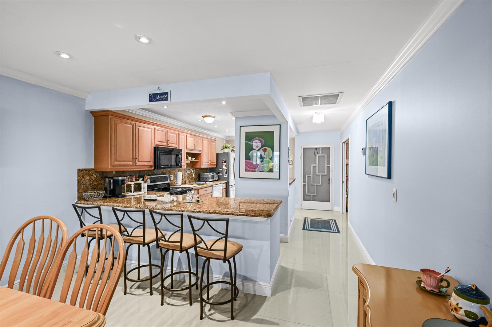A kitchen with wood cabinets, granite countertops, and a breakfast bar with three stools — 2730 SW 15th Street # a, Delray Beach FL 33445, DELRAY BEACH, FL