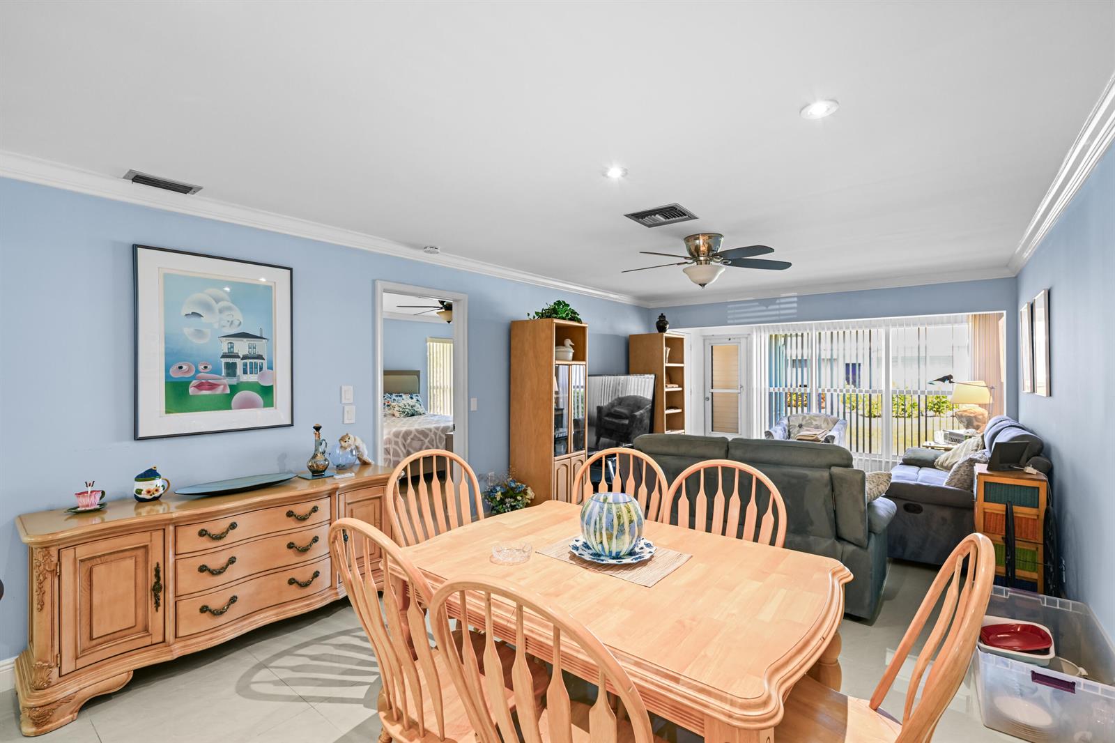 A dining area with light wood furniture opens into a living room with blue walls — 2730 SW 15th Street # a, Delray Beach FL 33445, DELRAY BEACH, FL