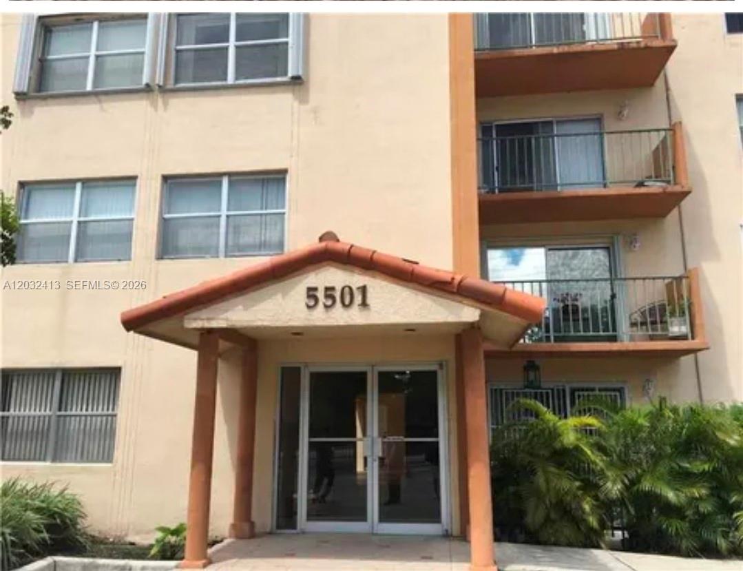 The exterior of a multi-story apartment building features a covered entrance with the number 5501 — 5501 NW 7th St # E408, Miami FL 33126, MIAMI, FL