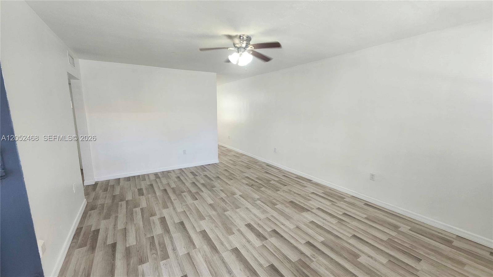 An empty room features white walls, a ceiling fan, and light-colored wood-look flooring — 111 NW 152nd St # 16, Miami FL 33169, MIAMI, FL