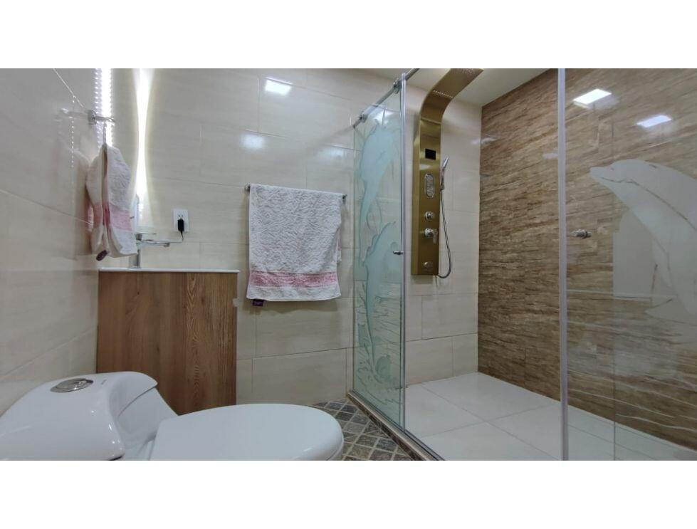 A bathroom features a white toilet, a wooden vanity, and a glass-enclosed shower with stone-look tiles — 8-77 Carrera 8va. Barrio Chipre # 77, FL