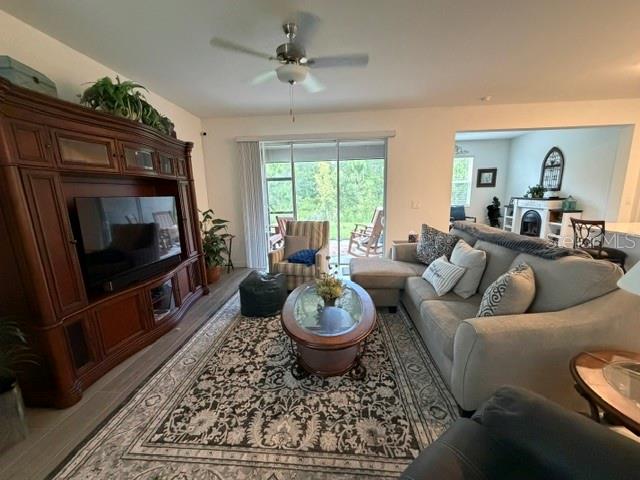 A living room features a large wooden entertainment center, a sectional sofa, and sliding doors — 9760 MINNOW RAY DRIVE, LAND O LAKES, FL