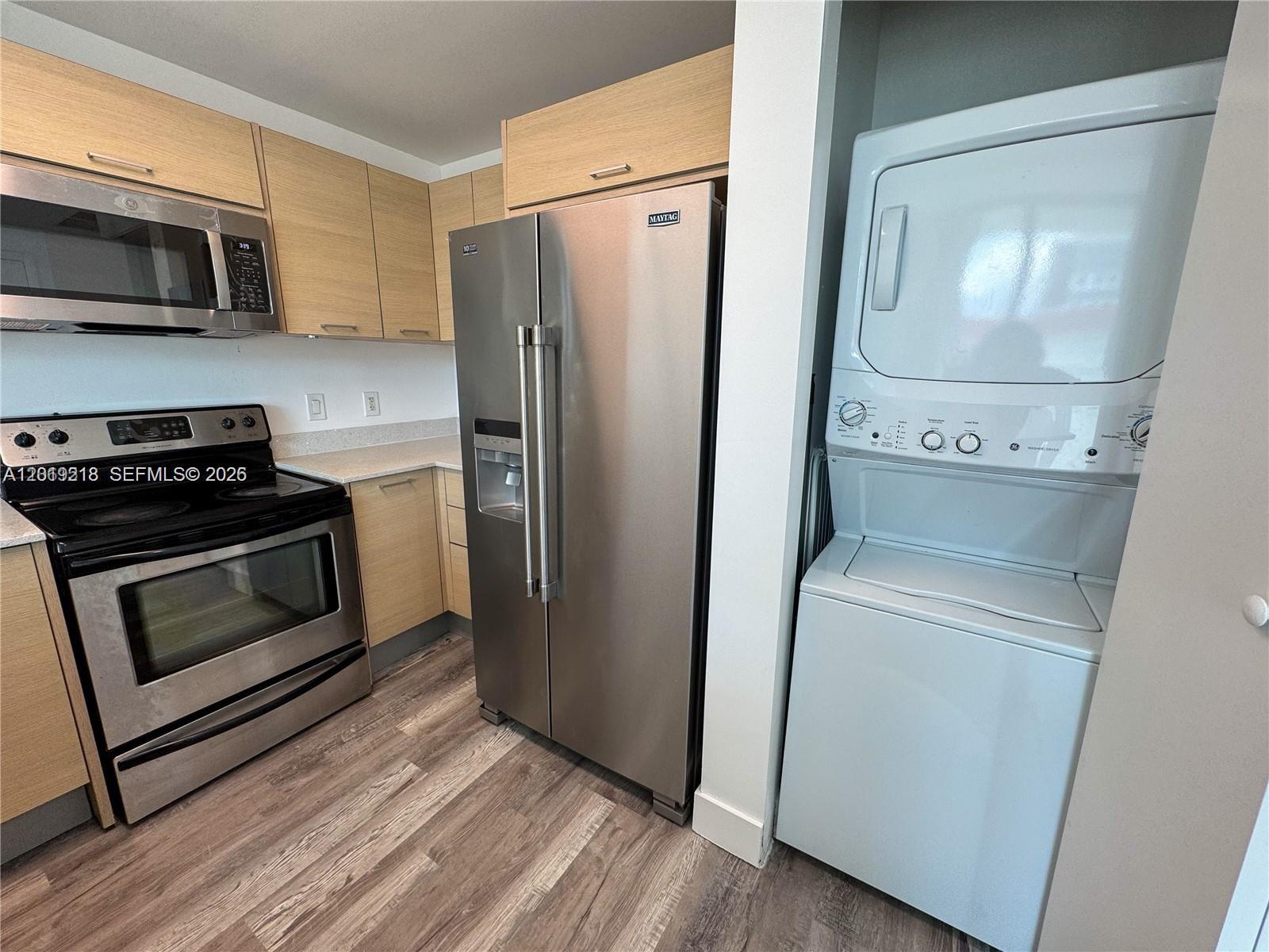 A kitchen features light wood cabinets, stainless steel appliances, and a stacked washer-dryer unit — 350 NE 24th St # 514, Miami FL 33137, MIAMI, FL