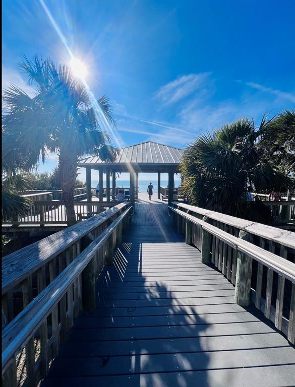 A wooden boardwalk leads to a covered pavilion overlooking the ocean under a sunny sky — 14307 HAYWARD AVENUE, PORT CHARLOTTE, FL
