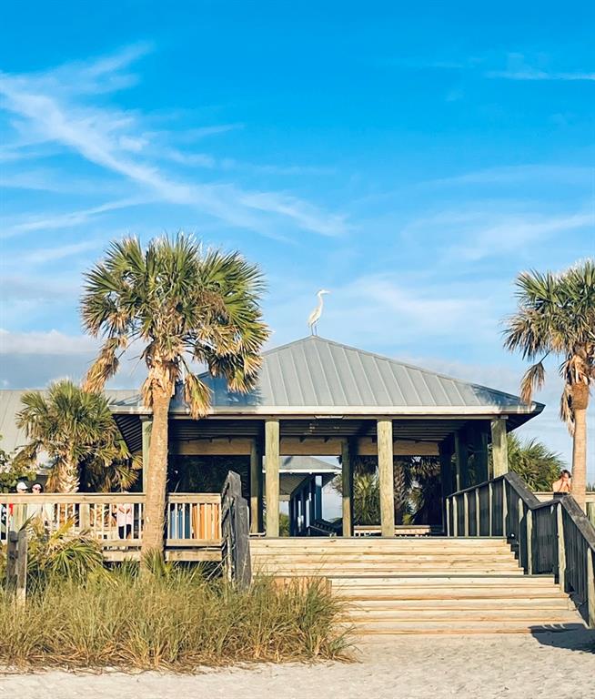 A wooden pavilion with a metal roof stands on a sandy beach with palm trees — 14307 HAYWARD AVENUE, PORT CHARLOTTE, FL