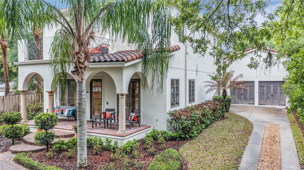 A two-story stucco house with a tiled roof, arched porch, and a detached garage — 18 CELIA LANE, ORLANDO, FL