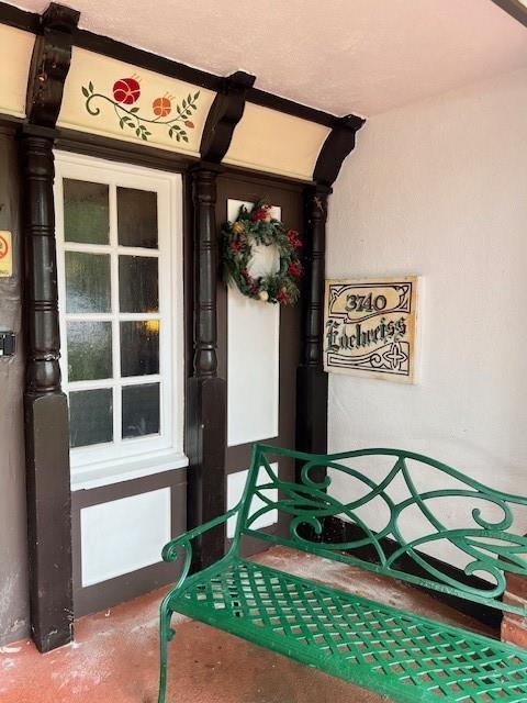 A green metal bench sits on a porch next to a door with a wreath — 3740 Inverrary Drive # 2u, Lauderhill FL 33319, LAUDERHILL, FL
