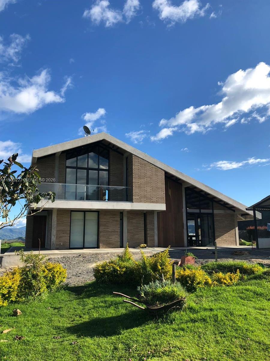 A modern two-story house with brick siding, large glass windows, and a sloped roof — 4.2 KILOMETRO NW VEREDA BOBADILLAS, Bg, Bg