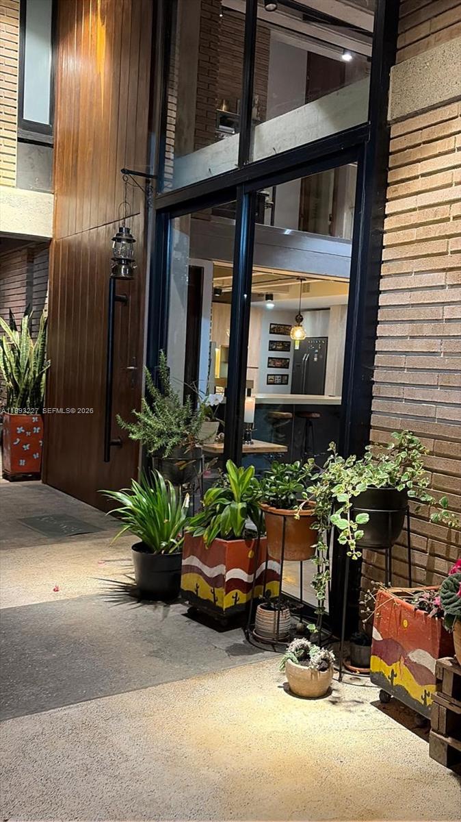 A patio features several potted plants, a wooden wall, and a view into a kitchen — 4.2 KILOMETRO NW VEREDA BOBADILLAS, Bg, Bg