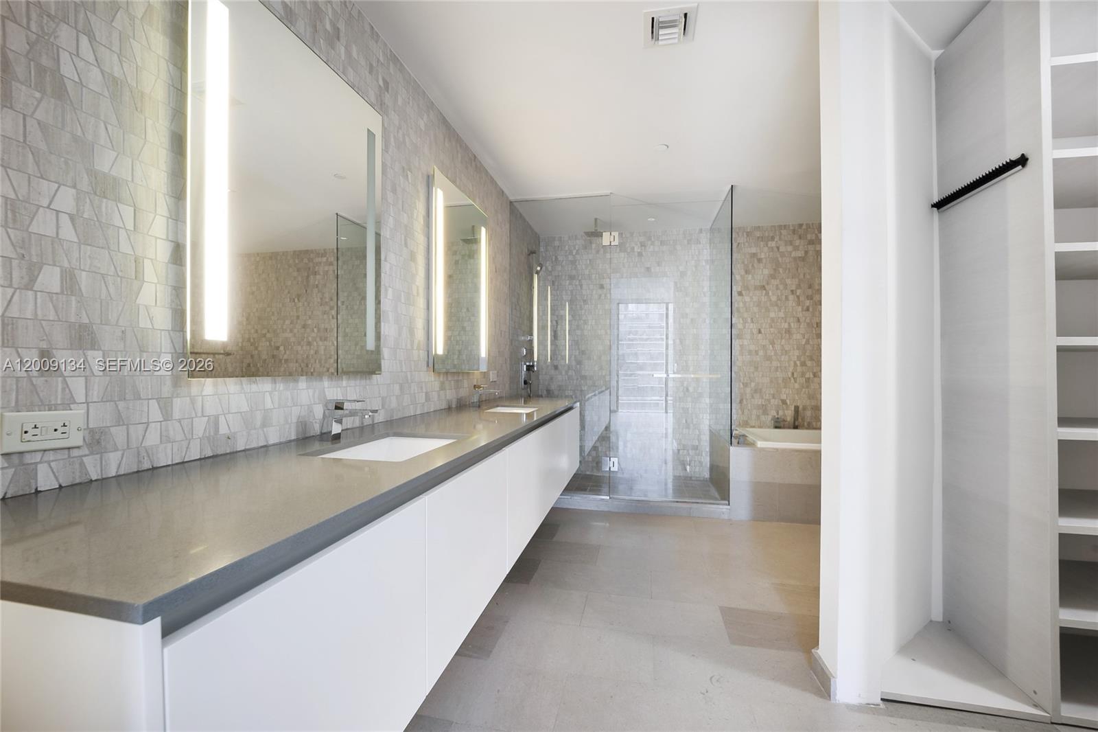 A modern bathroom features a long double vanity, a glass-enclosed shower, and a soaking tub — 88 SW 7th St # 1009, Miami FL 33130, MIAMI, FL