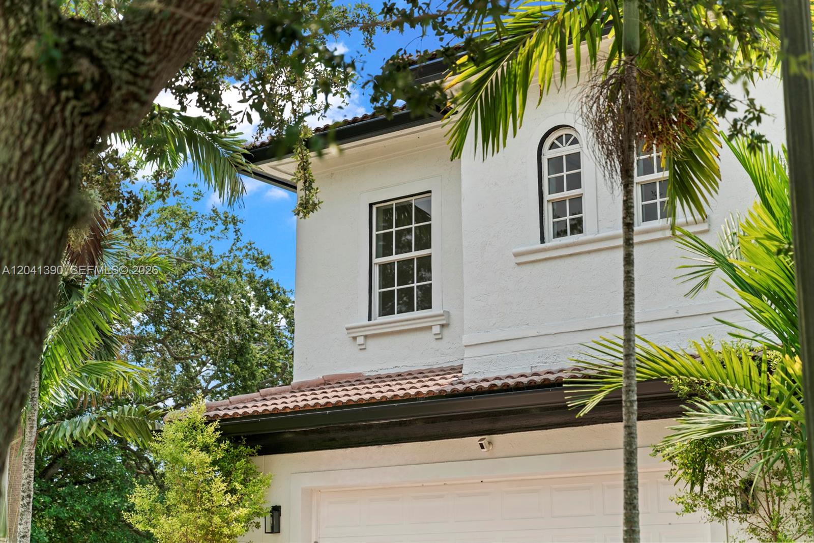 The exterior of a two-story white stucco house features a garage and arched windows — 3040 SW 44th Ct, Dania Beach FL 33312, DANIA BEACH, FL