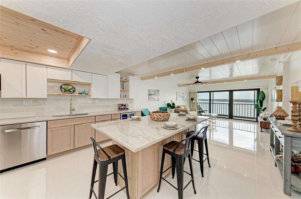 A modern kitchen with a large marble island, light wood cabinetry, and a waterfront balcony — 1510 1ST AVENUE W UNIT 503, BRADENTON, FL
