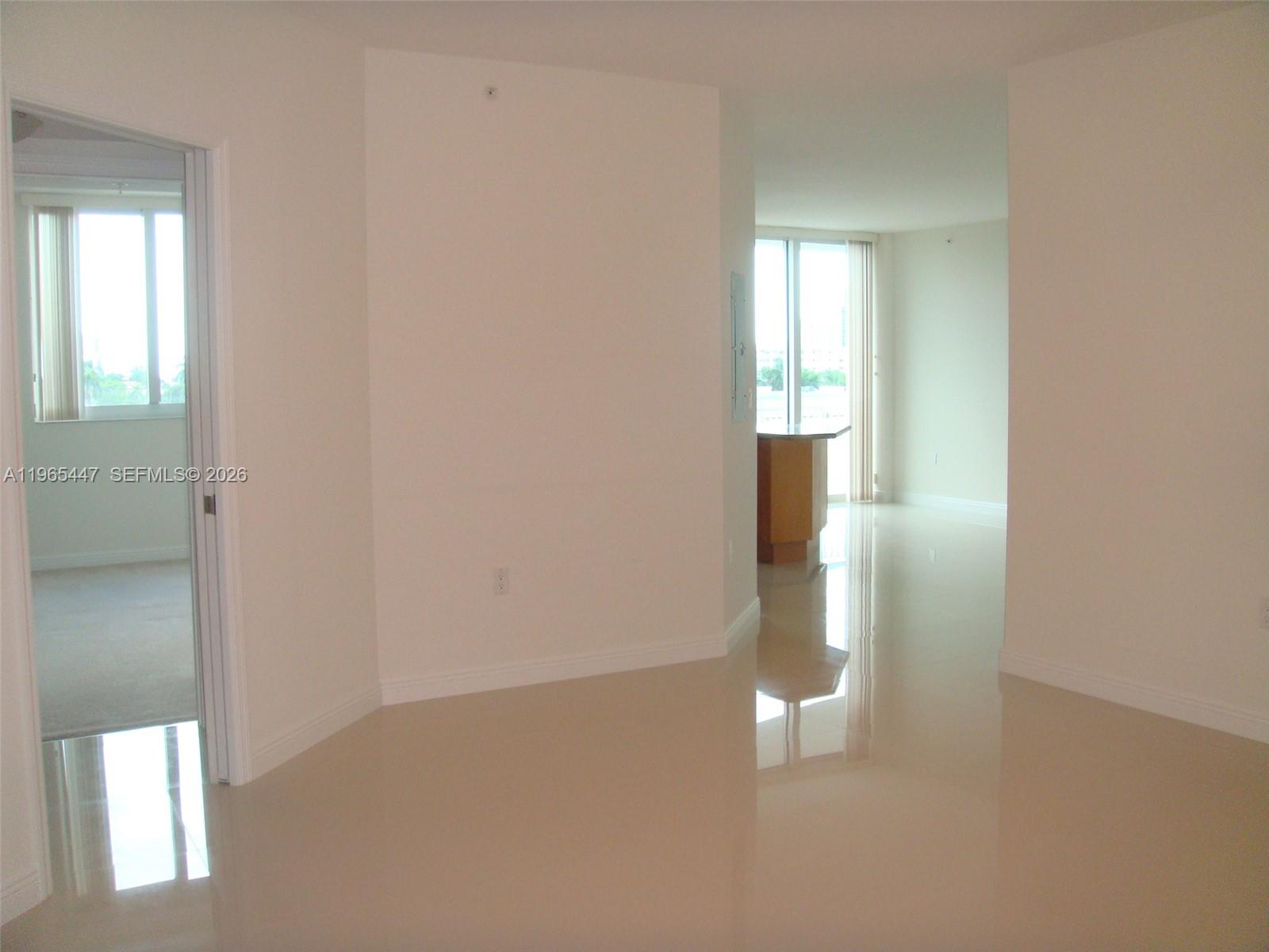 An interior view shows a hallway with light tile flooring leading to an open living area — 1755 E Hallandale Beach Blvd # 406E, Hallandale Beach FL 33009, HALLANDALE BEACH, FL