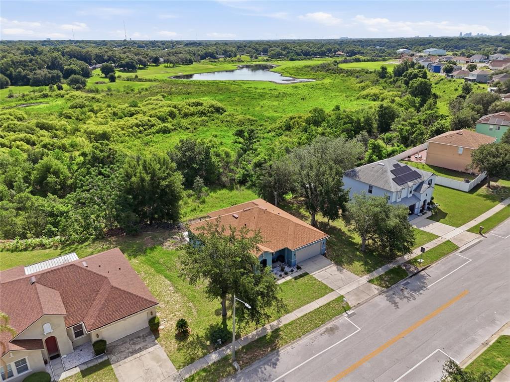 A blue single-story house with a brown shingled roof and a two-car garage — 7254 COUNTRY RUN PARKWAY, ORLANDO, FL