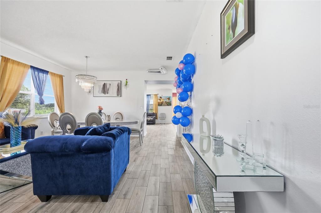 A living room features a blue sofa, a mirrored console table, and blue balloon decorations — 7254 COUNTRY RUN PARKWAY, ORLANDO, FL