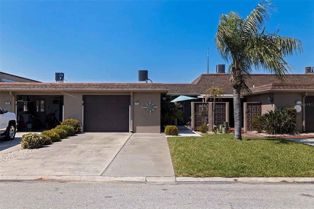 A single-story house with a brown garage, a concrete driveway, and a palm tree — 479 BOCA CIEGA POINT BOULEVARD S UNIT 1205, ST PETERSBURG, FL