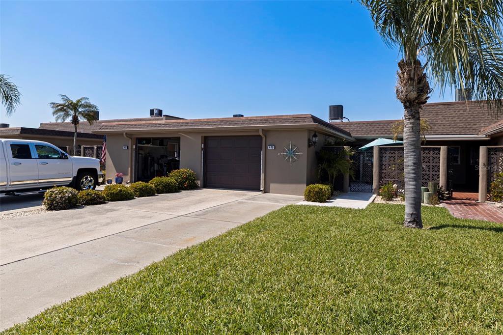 A single-story house with a brown roof, a garage, and a palm tree in front — 479 BOCA CIEGA POINT BOULEVARD S UNIT 1205, ST PETERSBURG, FL