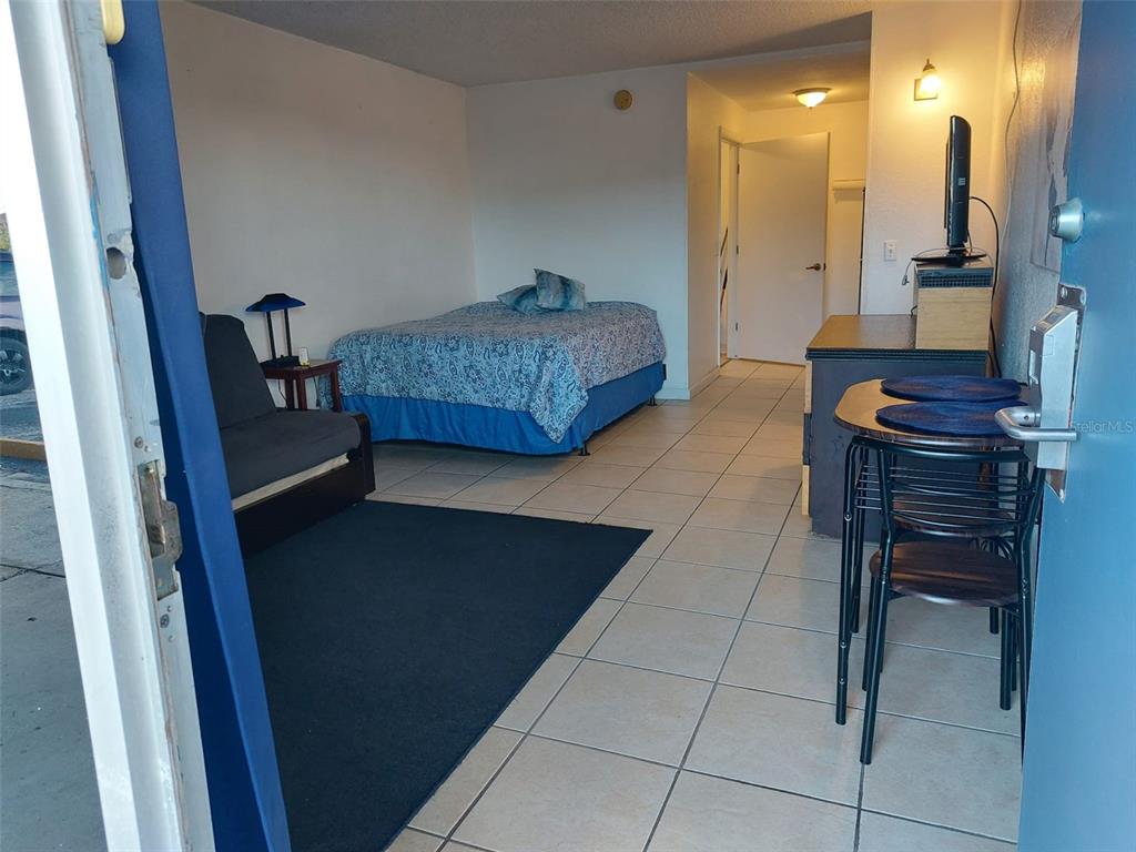 A studio apartment features a bed, a small sofa, a dining set, and tiled floors — 43420 HIGHWAY 27 UNIT 157, DAVENPORT, FL