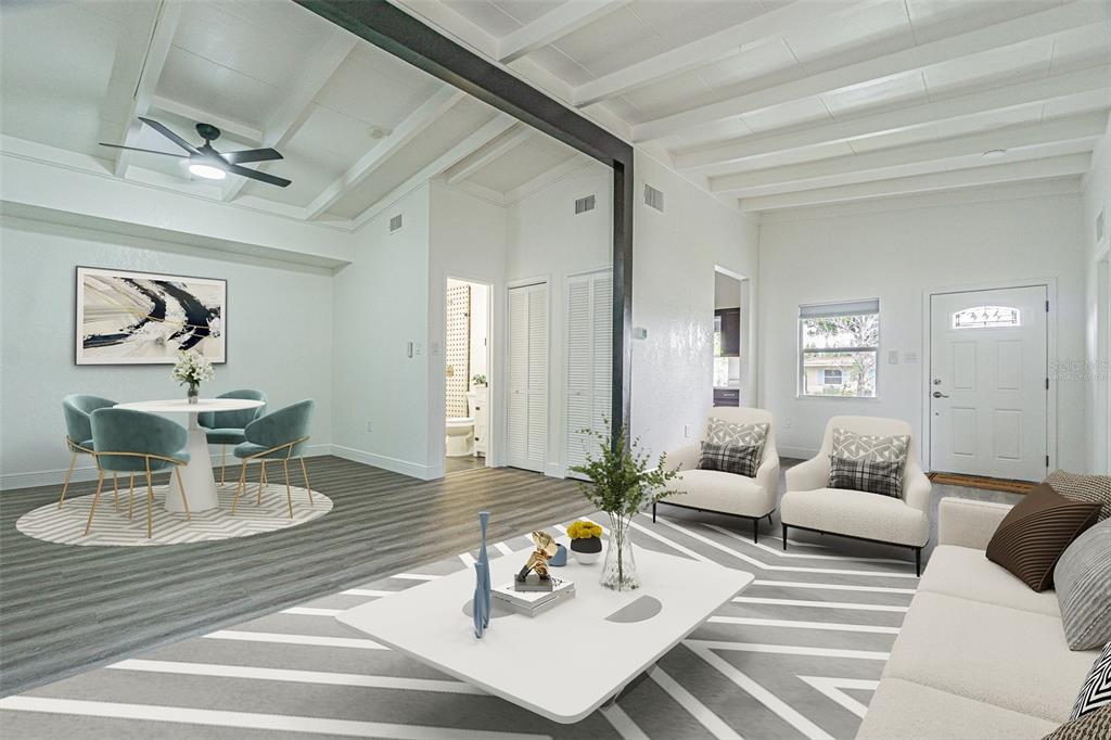 A bright living and dining area with white beamed ceilings, gray flooring, and modern furniture — 416 COUNTRY CLUB DRIVE, OLDSMAR, FL